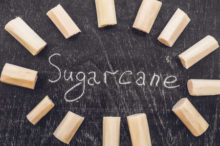 Pieces of cane sugar on the old wooden background. Sugar concept.の写真素材