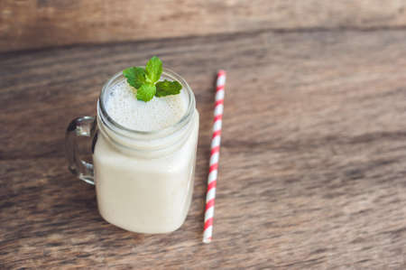 Banana cocktail and fresh bananas on the old wooden background, proper nutrition conceptの写真素材