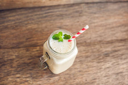 Banana cocktail and fresh bananas on the old wooden background, proper nutrition conceptの写真素材