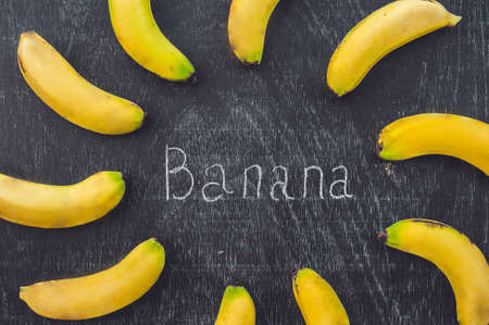 Banana cocktail and fresh bananas on the old wooden background, proper nutrition conceptの写真素材