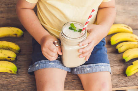 Boy holding a banana smoothie, proper nutrition conceptの写真素材