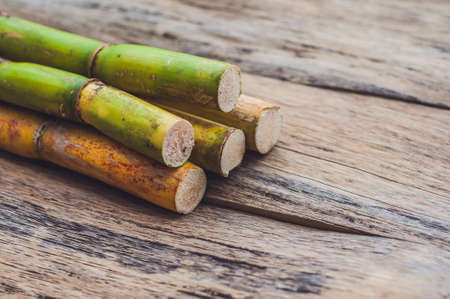 Stalks of sugar cane on the old wooden background. Cane sugar concept