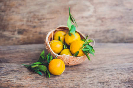 Fresh tangerines with leaves on the old wooden background.の写真素材