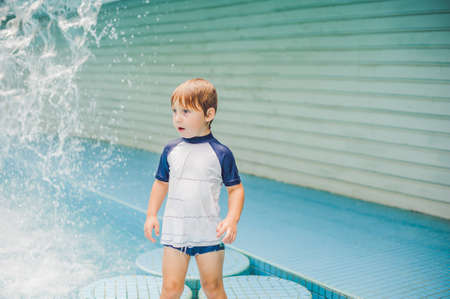 Boy playing in the paddling pool in the summertime.の写真素材