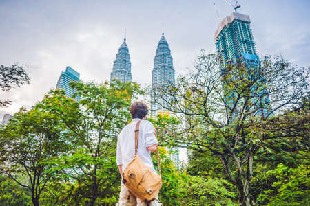 Man tourist in Malaysia looks at the Petronas Twin Towers.