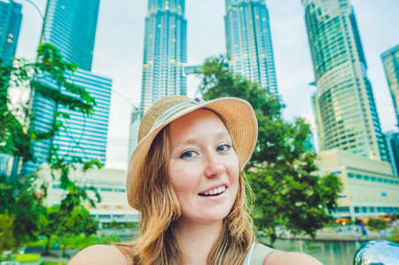 Young woman tourist making selfie on the background of skyscrapers. tourism, travel, people, leisure and technology concept.の写真素材