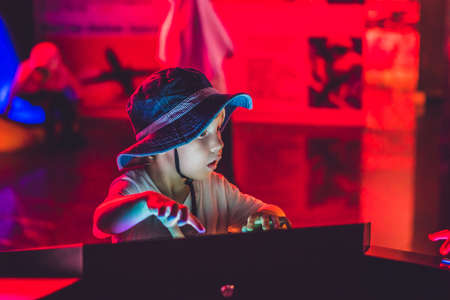 The boy looks an electronic map of the sky on the screen.