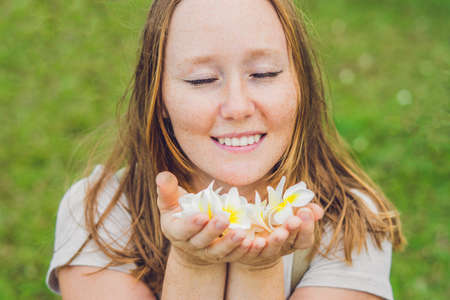 white flowers frangipani plumeria in female hands.の写真素材