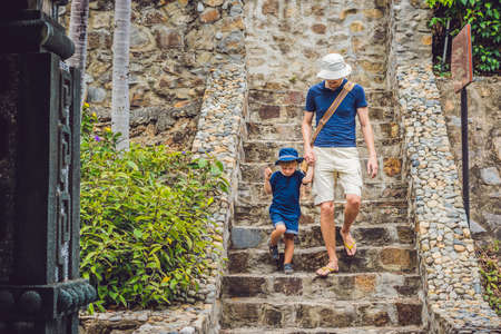 Father and son tourists go down the stairs.