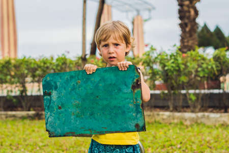 Sad boy standing with empty horizontal blank in handsの写真素材