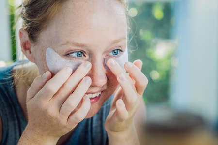 Portrait of Beauty Red-haired woman with eye patches showing an effect of perfect skin.の写真素材
