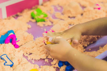Boy playing with kinetic sand in preschool. The development of fine motor concept. Creativity Game concept.の写真素材