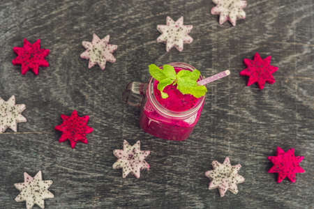 Pieces of sliced dragon fruit in the form of a star and smoothies from a dragon fruit on an old withered background.の写真素材