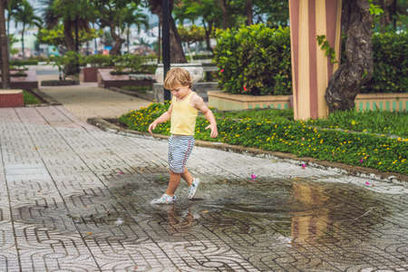 Little boy runs through a puddle. summer outdoor.の写真素材