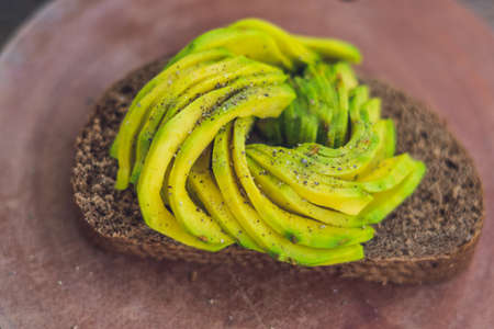 Avocado sandwich on dark rye bread made with fresh sliced avocados.の写真素材