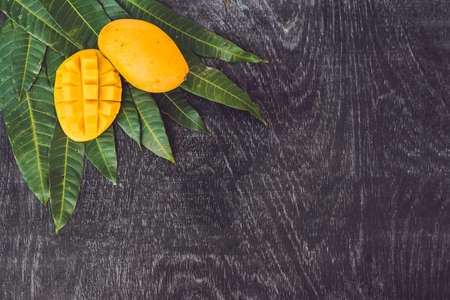 Mango and mango leaves on an old wooden background.の写真素材