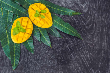 Mango and mango leaves on an old wooden background.の写真素材