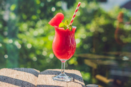 Healthy watermelon smoothie with mint and striped straws against the background of greenery.の写真素材