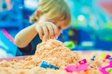Boy playing with kinetic sand in preschool. The development of fine motor concept. Creativity Game concept.の写真素材