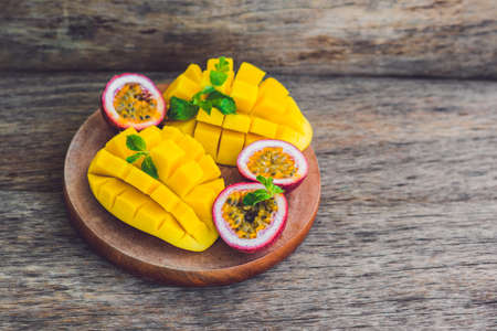 Mango and passion fruit on an old wooden background.の写真素材