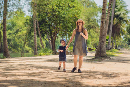 Mom and son are walking on the forest road.の写真素材