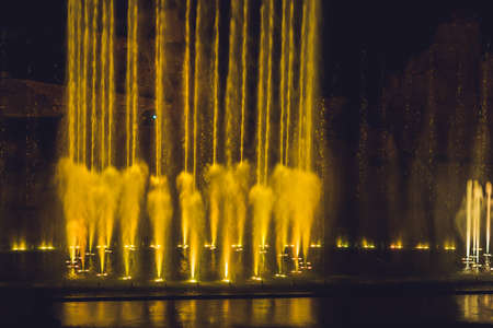Multicolored dancing water jet fountain in the dark.