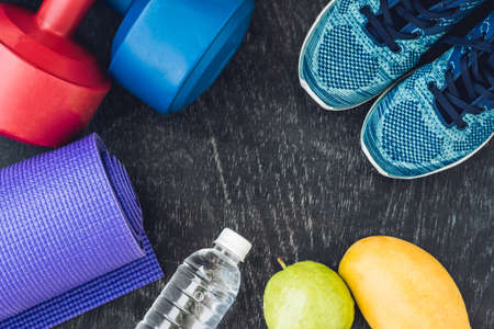 Yoga mat, sport shoes, dumbbells and bottle of water on blue background. Concept healthy lifestyle,...