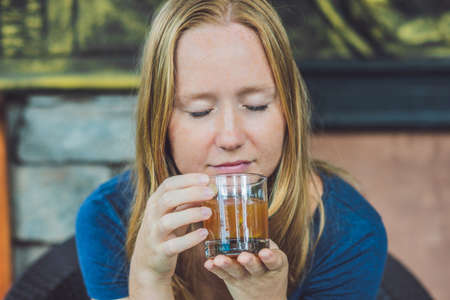 Pretty young woman holding a cup of hot citrus tea or hot lemonade.の写真素材