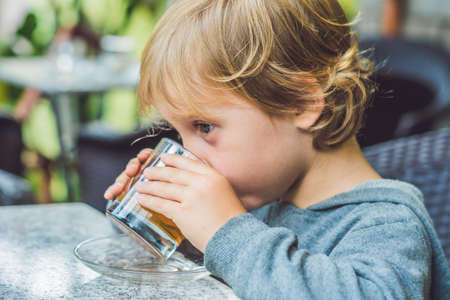 Cute little boy drinking tea in cafeteria.の写真素材