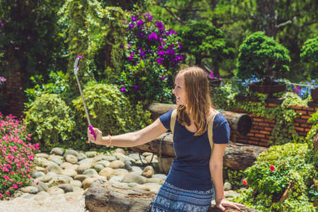 young beautiful girl doing selfie mobile phone in the park on summer day.の写真素材