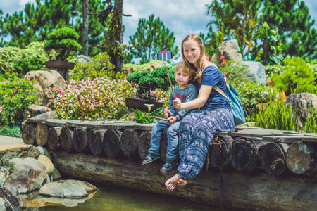 Mother and son doing selfie mobile phone in the park on summer day.の写真素材
