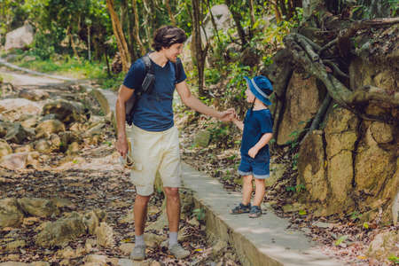 Father and son are walking along the forest road.の写真素材