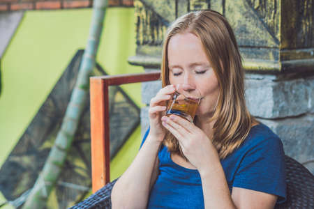 Pretty young woman holding a cup of hot citrus tea or hot lemonade.の写真素材