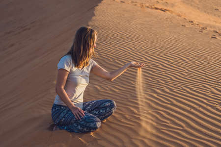 young woman in rad sandy desert at sunset or dawnの写真素材