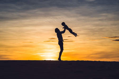Father and son at the red desert at dawn. Traveling with children concept.の写真素材