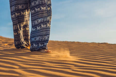 young woman in rad sandy desert at sunset or dawnの写真素材