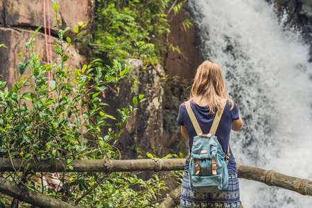 woman in the background of beautiful cascading Datanla waterfall In the mountain town Dalat,...