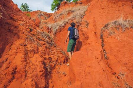 Young man in red canyon near Mui Ne, southern Vietnam.