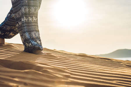 young woman in rad sandy desert at sunset or dawnの写真素材