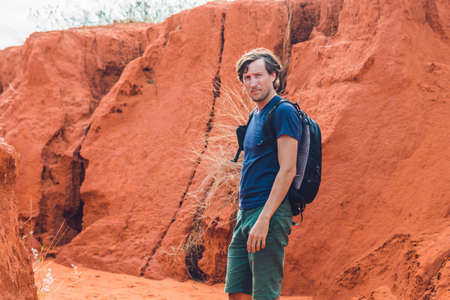 Young man in red canyon near Mui Ne, southern Vietnam.