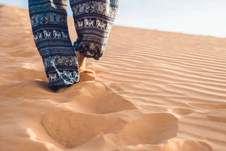 young woman in rad sandy desert at sunset or dawnの写真素材