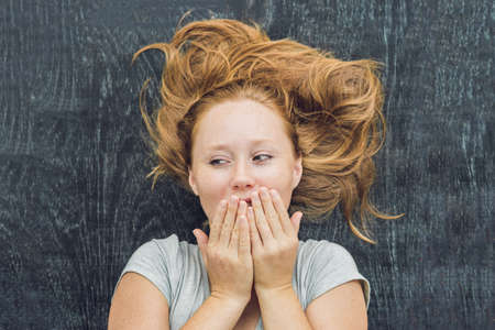 Top view of a young woman with space for text and symbols on the old wooden background. Concept for confusion, brainstorming and choice.の写真素材