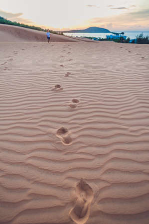 Footprints in the sand in the red desert at Sunrise.の写真素材