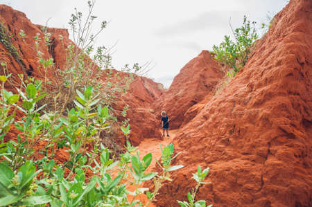 Young boy in red canyon near Mui Ne, southern Vietnam. Traveling with children conceptの写真素材