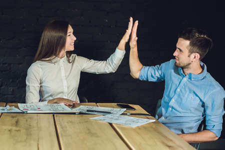 Young team of coworkers making great meeting discussion in modern coworking office. Teamwork process. Horizontal,blurred background.の写真素材