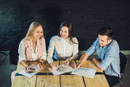 Young team of coworkers making great meeting discussion in modern coworking office. Teamwork process. Horizontal,blurred background.の写真素材