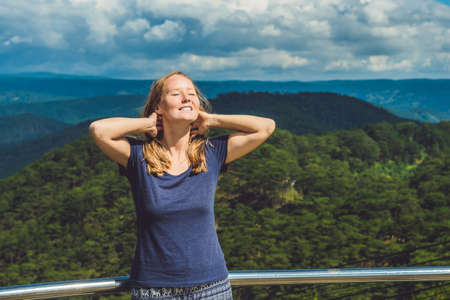 Hiker with backpack relaxing on top of the mountain. Ecotourism concept image, with happy female hiker.の写真素材