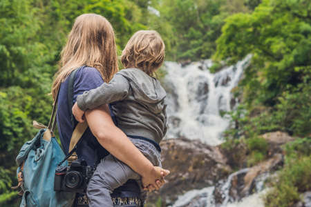 Mother and son in the background of beautiful cascading Datanla waterfall In the mountain town...