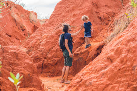 Father and son travelers in red canyon near Mui Ne, southern Vietnam. Traveling with children...