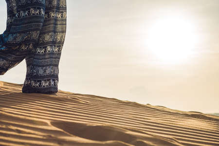 young woman in rad sandy desert at sunset or dawnの写真素材